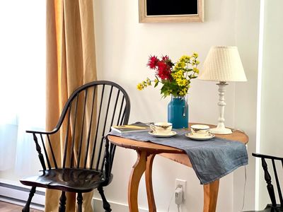 Chambre lumineuse avec table d'appoint et chaise Windsor