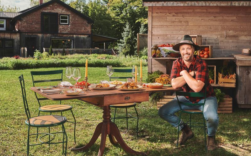 Jean-Martin Fortier attable devant le Old Mill